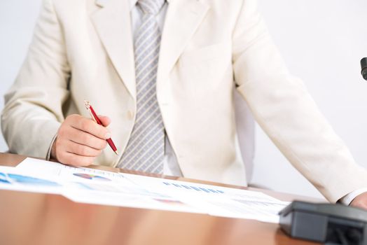 businessman sitting at a table and holding a pen