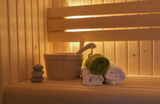 sauna interior with towels and wooden bucket