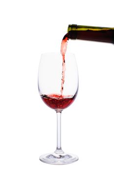 Red wine pouring into wine glass isolated on white background