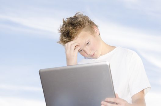 High key portrait of teenager with laptop against blue sky background