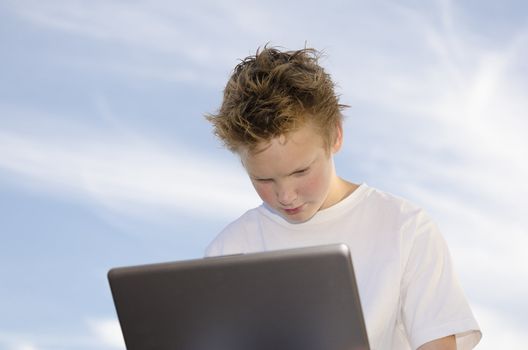 Thoughtful teen work on a computer through the wireless network