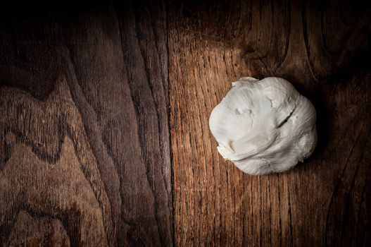 garlic on brown textured wood