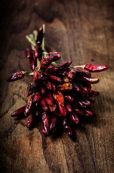 dried hot red chilies on brown textured wood