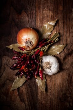 composition of chilies, onion and garlic on wood