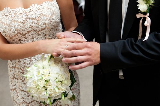 groom putting on a wedding ring to a bride