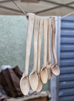 Wooden spoons and a fork pending from a wire