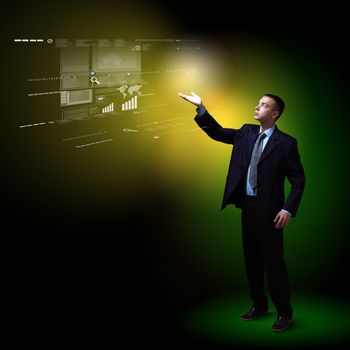 Businessman standing with modern technology symbols next to him