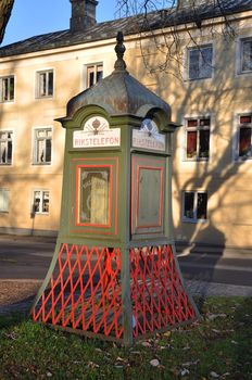 Antique telephone booth on a street in a small city.