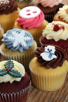 Photo of many cupcakes decorated for Christmas. Focus on snowman.
