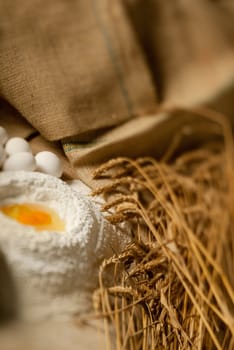 Eggs, wheat and flour on a baking table with a tilt shift lens