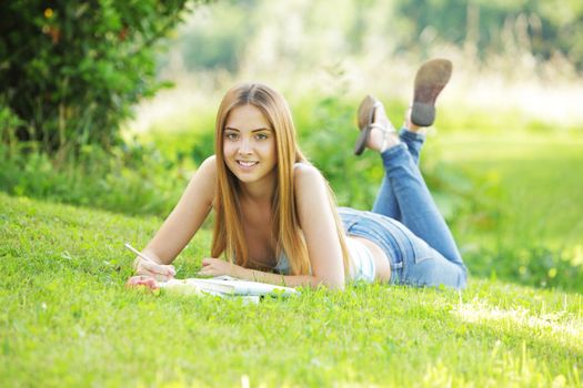 Teenage female student reading on Campus Lawn