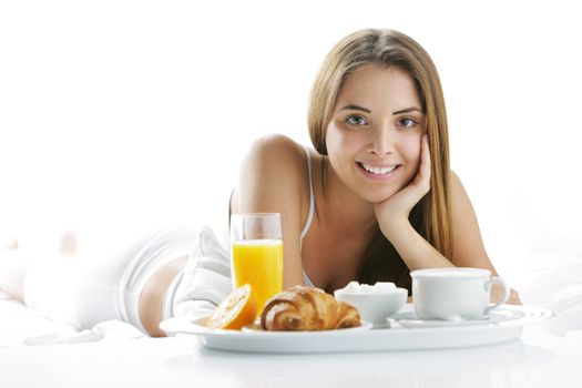 Young beautiful woman having breakfast in bed.