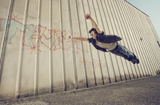 A young man feels like a superhero, flying free.