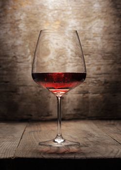 A red wine glass on wooden background