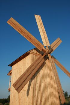 Rural wooden windmill against clear deep blue sky