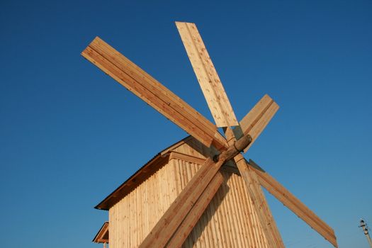 Rural wooden windmill against clear deep blue sky