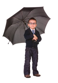 Calm boy in black clothes standing under big black umbrella isolated on white