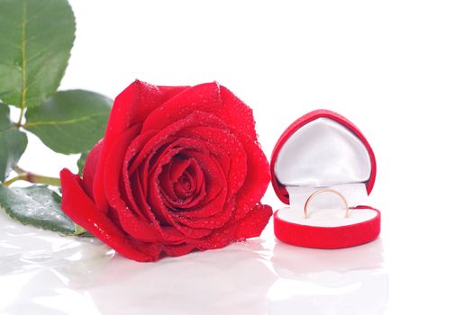 Ring in the package, and a red rose isolated on white background
