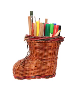 pencil holder - old handmade trellis boot - with lots of pencils and crayons over white background