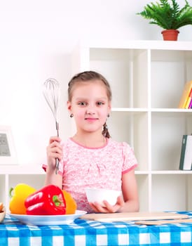 Beautiful girl holding a mixer, work in the kitchen