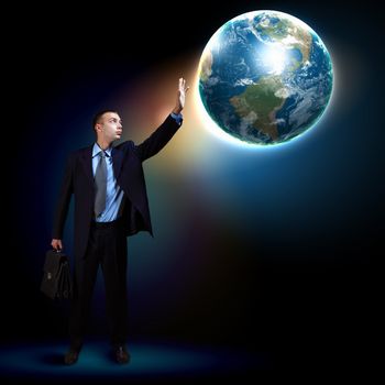 Businessman standing with our planet Earth. Elements of this image are furnished by NASA