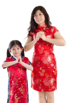 Chinese family in traditional Chinese cheongsam blessing, isolated on white background 