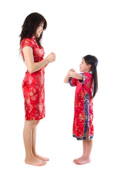 Chinese parent and child in traditional Chinese cheongsam greeting, isolated on white background 