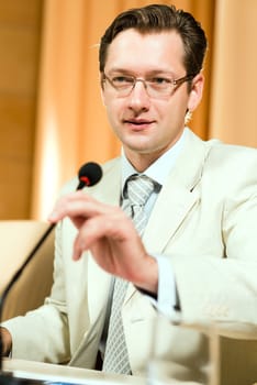 Portrait of a business man holding a microphone and looks ahead