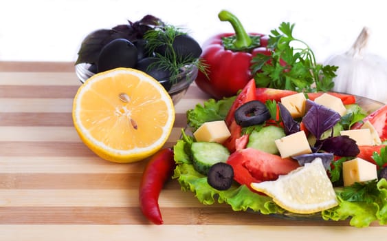 salad and vegetables. Pepper, garlic, lemon and parsley on the board isolated on white background