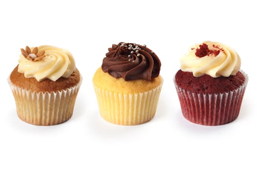 Photo of three different flavored cupcakes on white background.
