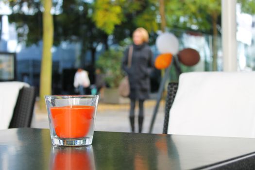 The candle on the table in the autumn cafe