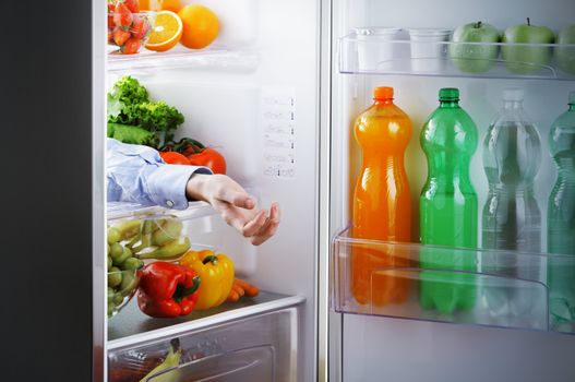 the arm of a man in the refrigerator