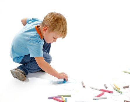 Little Boy Drawing with Colour Chalk on white background