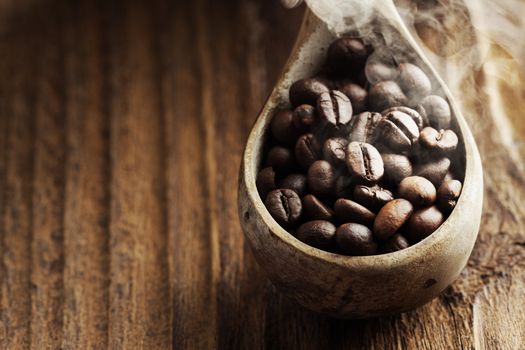 Close up of wooden spoon with coffee beans on it