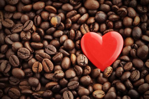 Textures of roasted coffee beans with red heart for background