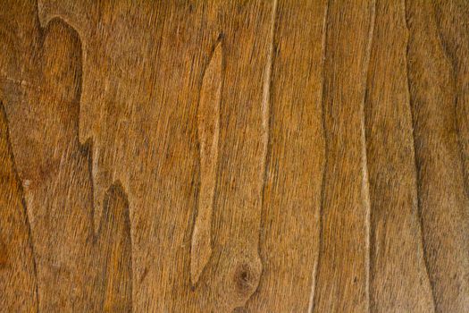 A wood grain background texture detail abstract. The wood color is rich brown in tone and the image is horizontal.