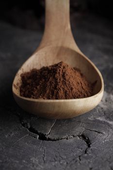 Wooden spoon full of cocoa powder