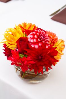 Wedding decor at a ceremony and reception with beautiful red and yellow flowers.