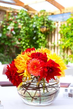 Wedding decor at a ceremony and reception with beautiful red and yellow flowers.