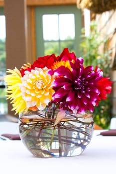 Wedding decor at a ceremony and reception with beautiful red and yellow flowers.