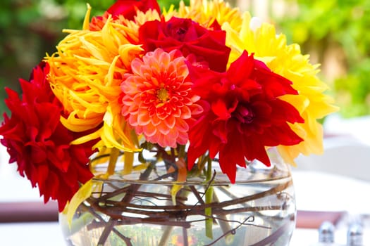 Wedding decor at a ceremony and reception with beautiful red and yellow flowers.