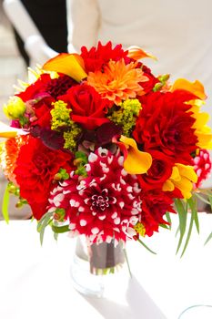 Wedding decor at a ceremony and reception with beautiful red and yellow flowers.