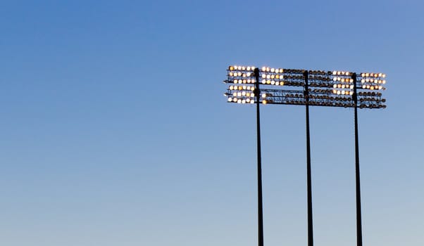 Stadium lights over a blue sky