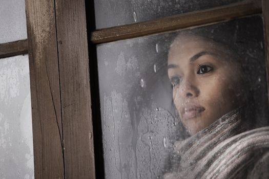 Portrait of a beautiful girl behind window 