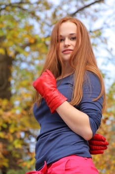 Close-up portrait of a beautiful red-headed girl posing outdoors