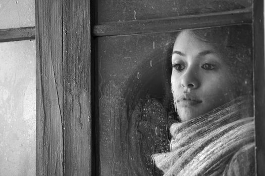 Portrait of a beautiful woman behind window 