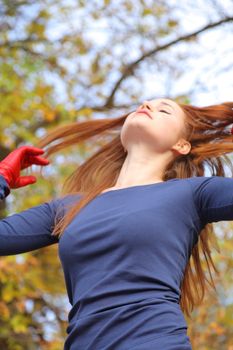 portrait of a beautiful red-headed girl posing outdoors