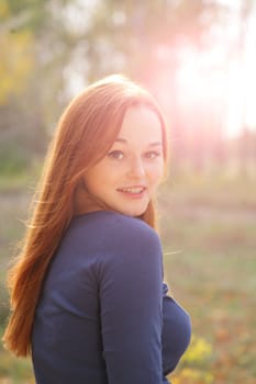 portrait of cute red haired young woman, outdoor, backlit