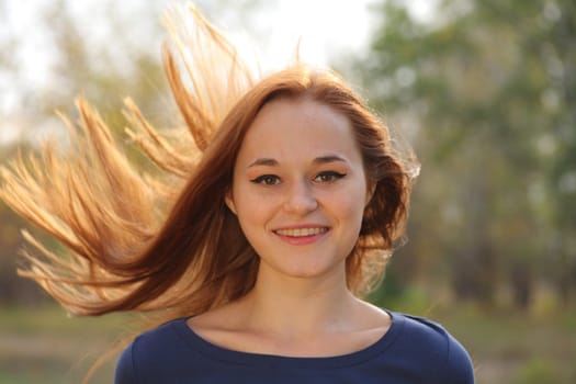 Young redhead woman in the park having fun