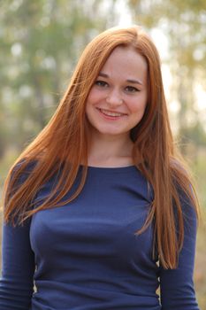 Attractive redhead in autumn having fun